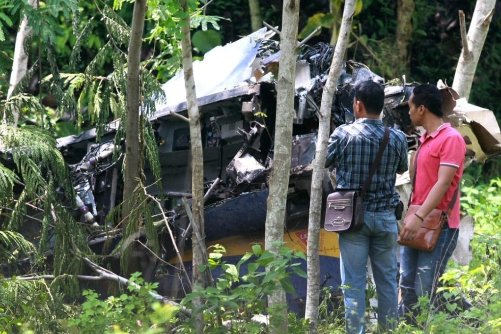 Soldiers in plain clothes inspect the wreckage of the South Korean-made trainer aircraft. Photo: EPA