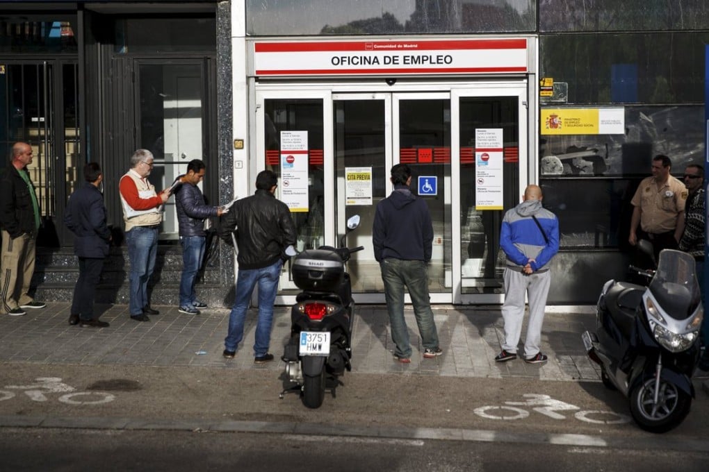People stand in a line to enter a government employment office in Madrid, Spain. Photo: Reuters