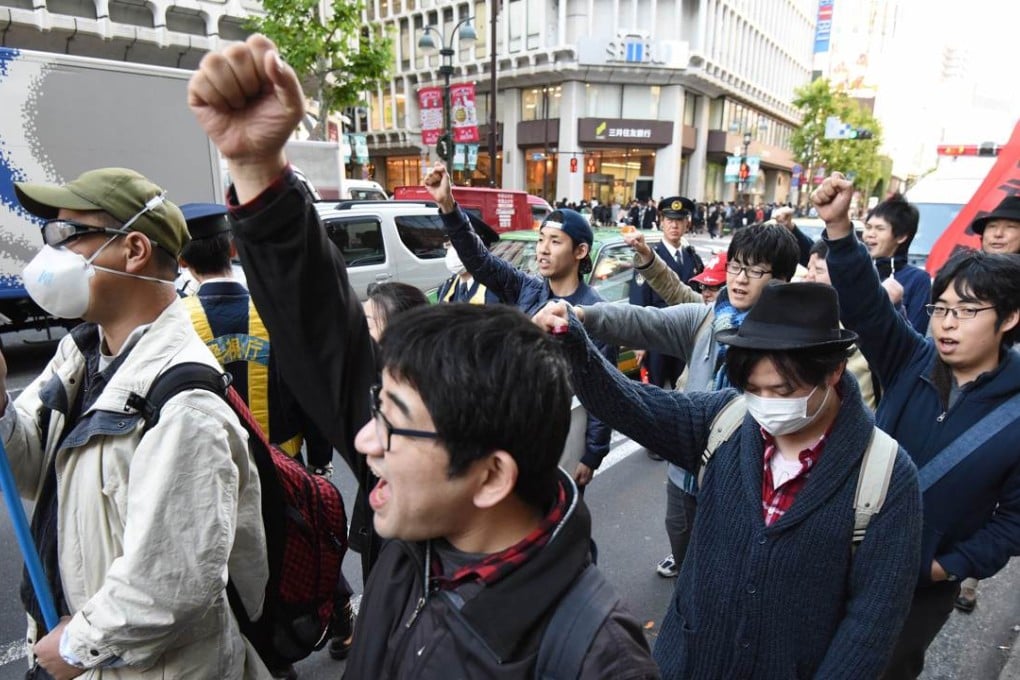 Members of a group of men calling themselves "Losers with Women", shout anti-Christmas slogans in Shibuya shopping district in Tokyo. Photo: AFP