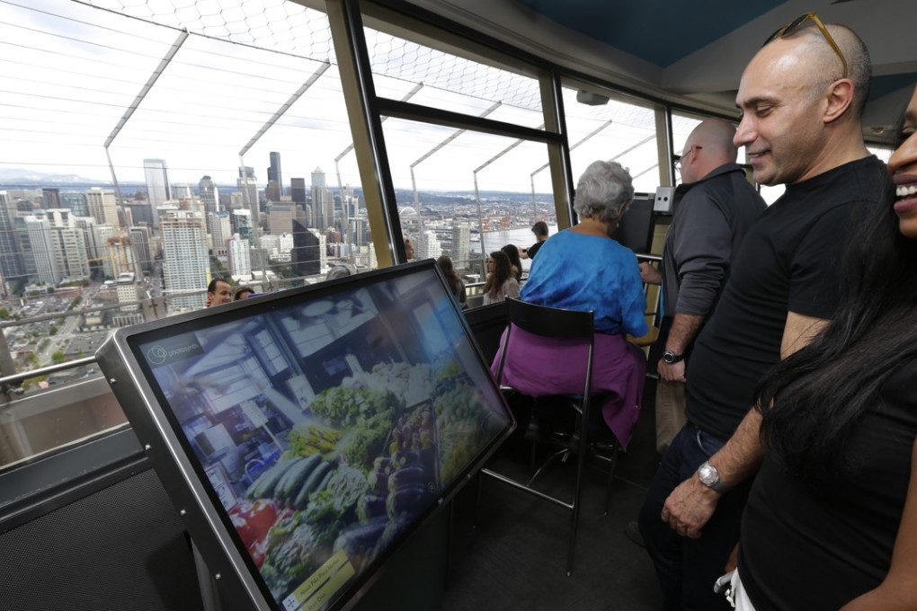 Anan Bishara, left, and Denise Burrell, both from New York, check out a virtual reality display atop the Space Needle in Seattle. The hi-tech attractions are part of an explosion of virtual reality in the travel industry. Photo: AP