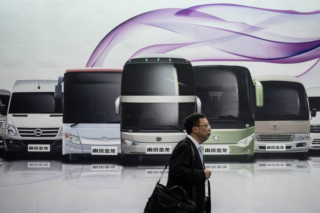 A man walks past a billboard showing electric buses during the China International New Energy Vehicle show in Hong Kong last month. Photo: AFP