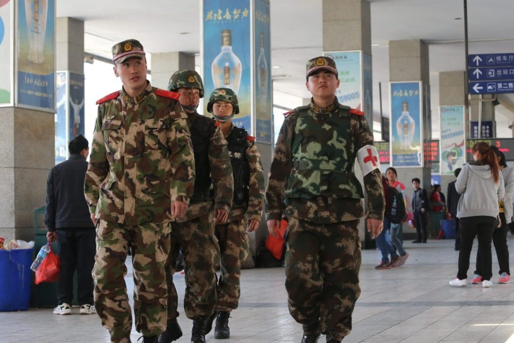 Paramilitary police patrol inside Kunming railway station after 31 people were stabbed to death and 141 others were wounded by a group of knife-wielding men in Kunming in 2014. Photo: EPA ,