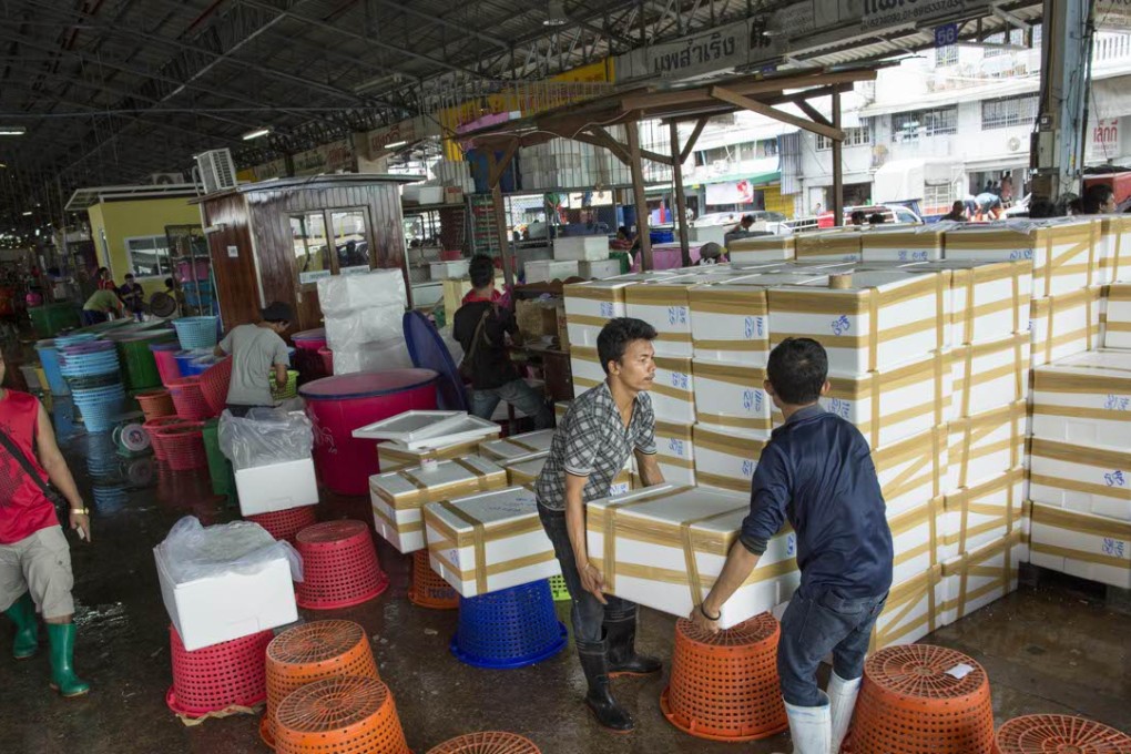 Workers carry boxes filled with iced shrimp at a seafood market in Mahachai, Thailand. Thailand sends nearly half of its shrimp to the US. Photo: AP