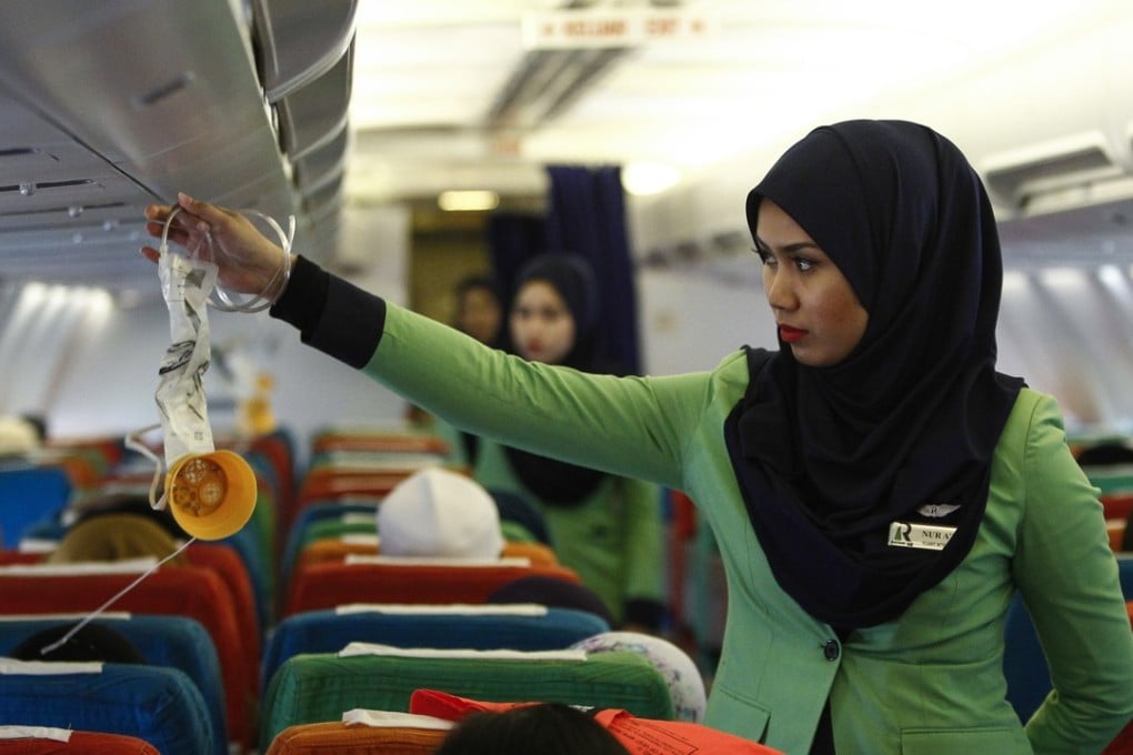 A Rayani Air flight crew demonstrates a safety brief before departure at the Sultan Ismail Petra Airport in Kelantan, Malaysia. Photo: AP