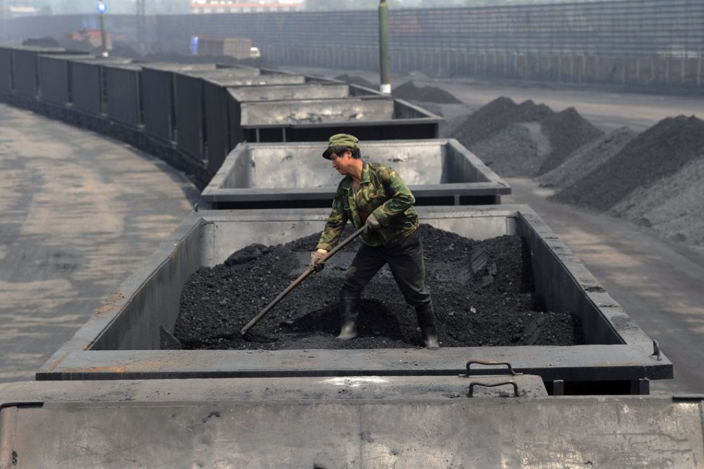 A worker levels the coal on a freight train in Taiyuan in northern China's Shanxi province. Photo: AP