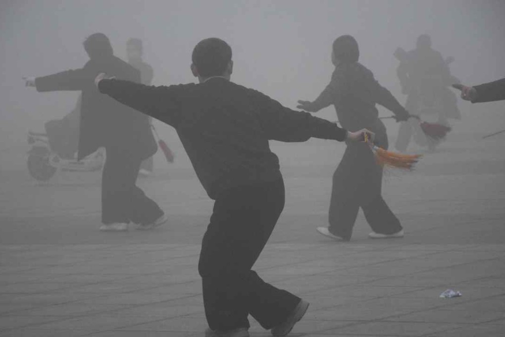 Residents in China’s Ruan county, Henan province, perform their early-morning exercise routines on the street amid thick smog. Photo: Xinhua