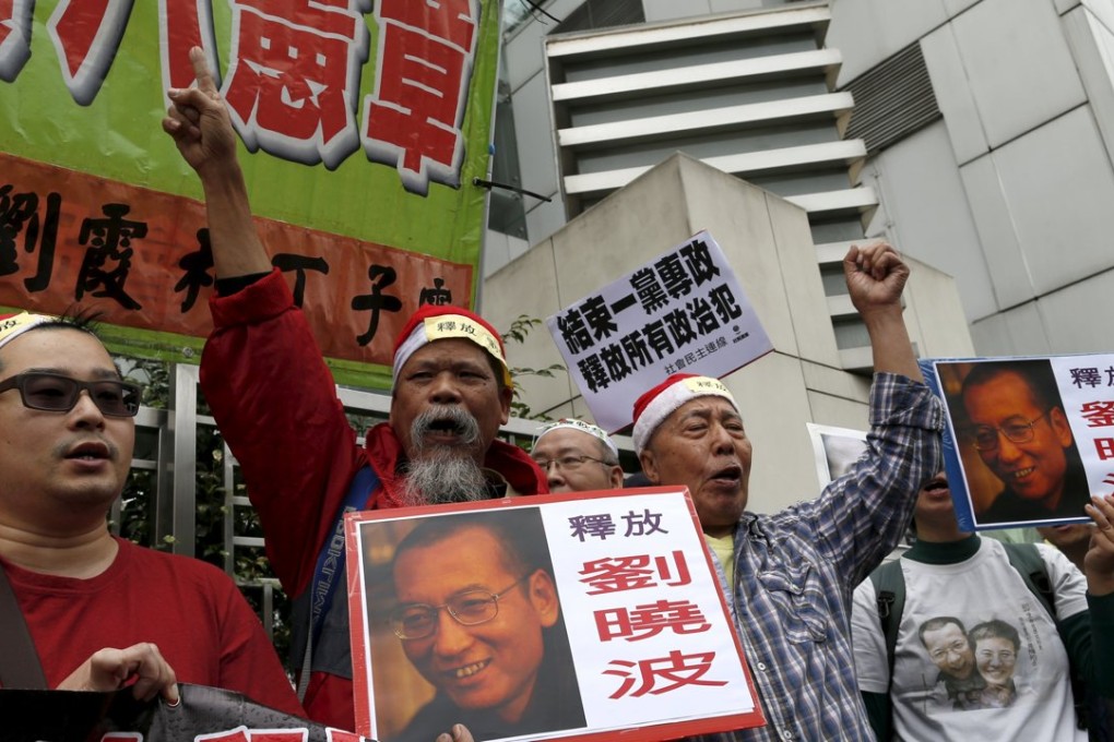Pro-democracy demonstrators hold up signs and posters of jailed Chinese Nobel Peace Prize laureate Liu Xiaobo during a protest outside the Chinese liaison office in Hong Kong today. Photo: Reuters