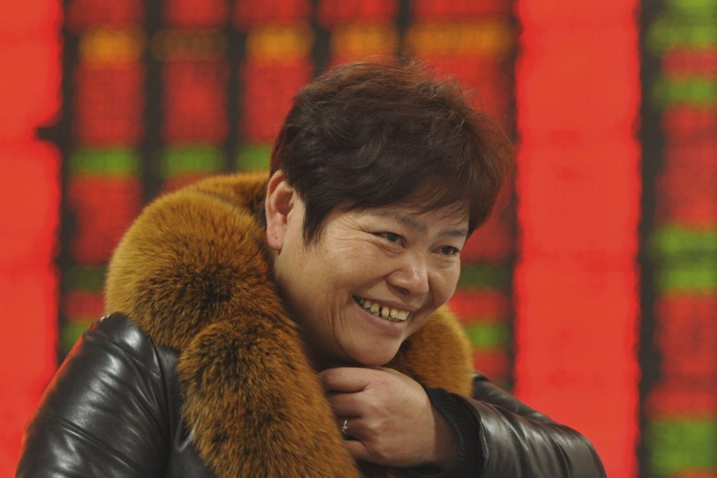 An investor smiles in front of an electronic board showing stock information at a brokerage house in Fuyang on December 21. Photo: Reuters, 2015