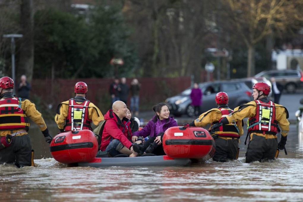 Members of the emergency services transport residents to safety after their homes were affected by floodwaters in York, northern England, on Sunday. Photo: AFP