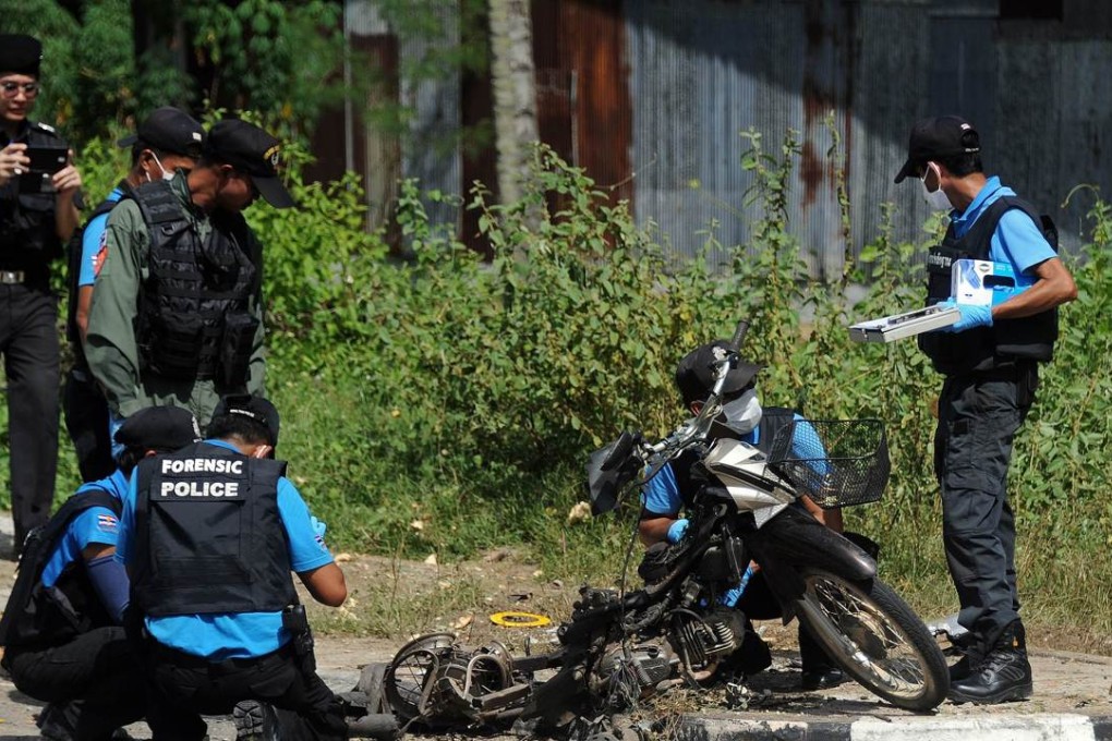 Thai bomb squad members inspect the site of a motorcycle bomb attack targeting a police patrol in the Takbai district of Thailand's restive southern province of Narathiwat. Photo: AFP