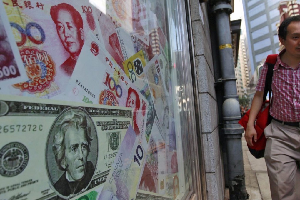 A man walks past an oversized Chinese yuan, the US dollar and other foreign currencies outside a foreign exchange shop in Hong Kong where the peg to the greenback can weigh on Hong Kong when the US Fed raises rates as it did on December 16. Photo: EPA