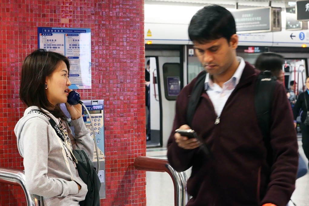 A passenger uses a payphone inside Central station. Photo: Felix Wong
