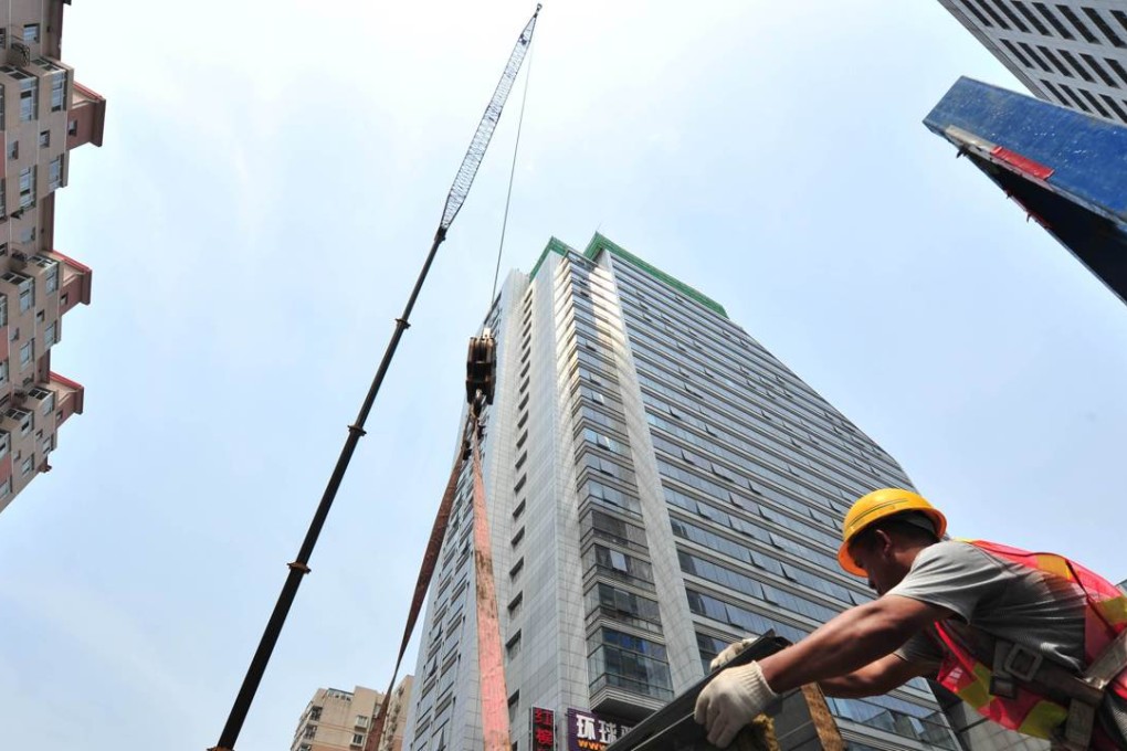 Workers on a rooftop in Beijing as sizzling land prices fire up the market in mainland China. Photo: AFP