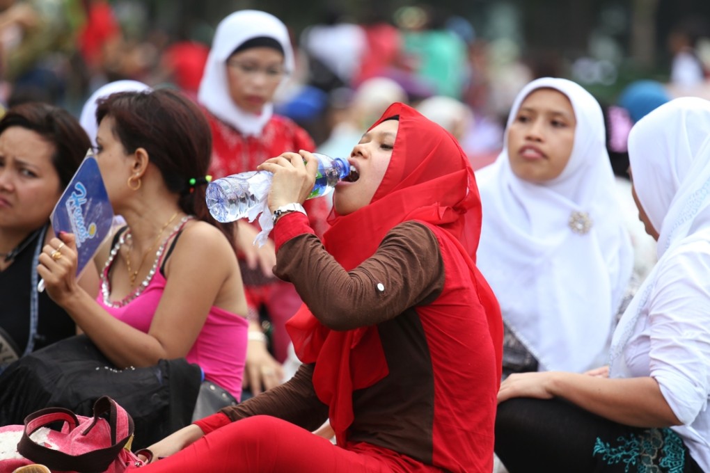 Maids cool off in hot weather as they celebrate Indonesian National Day at Victoria Park in August. Photo: Nora Tam