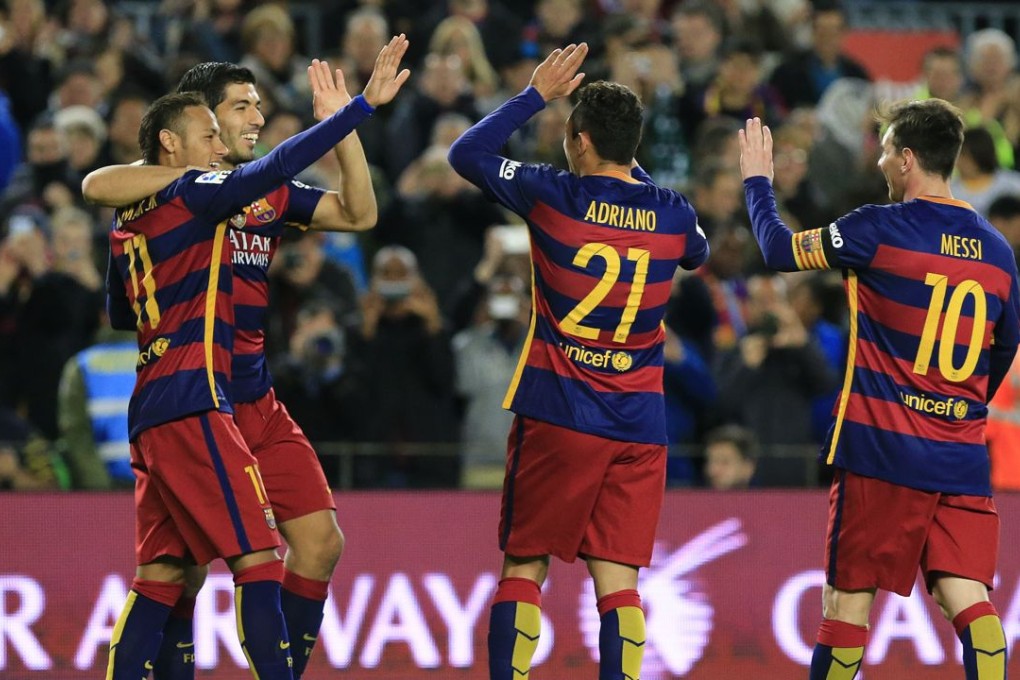 Barcelona's Uruguayan forward Luis Suarez celebrates with team-mates after scoring against Real Betis. Photo: AFP
