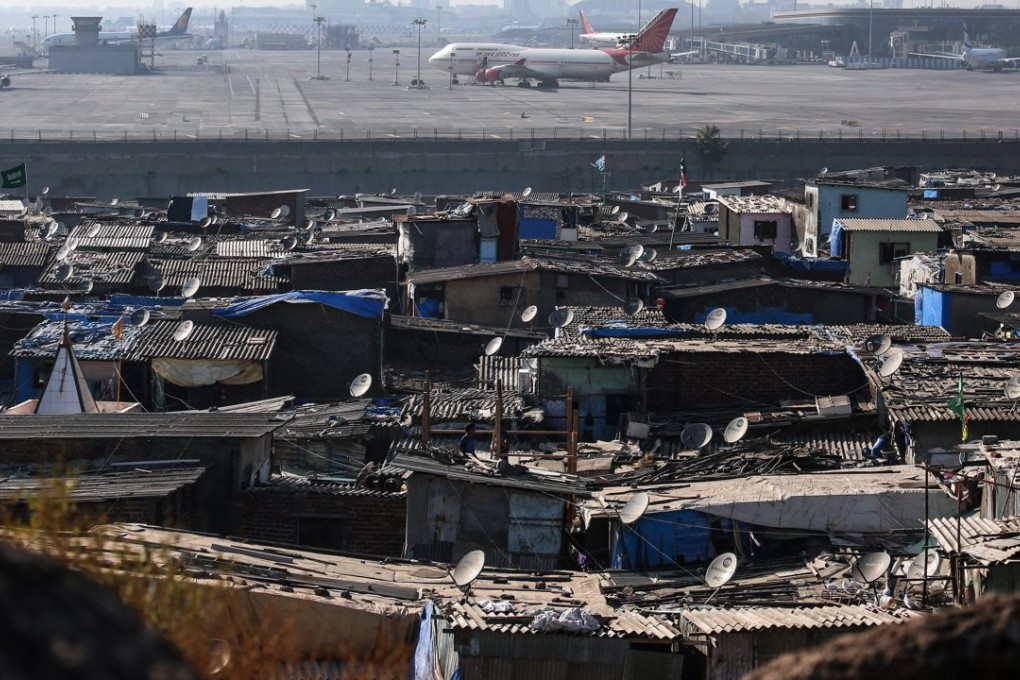 Slums are seen just outside the security fence of Chhatrapati Shivaji International Airport in Mumbai. Photo: EPA