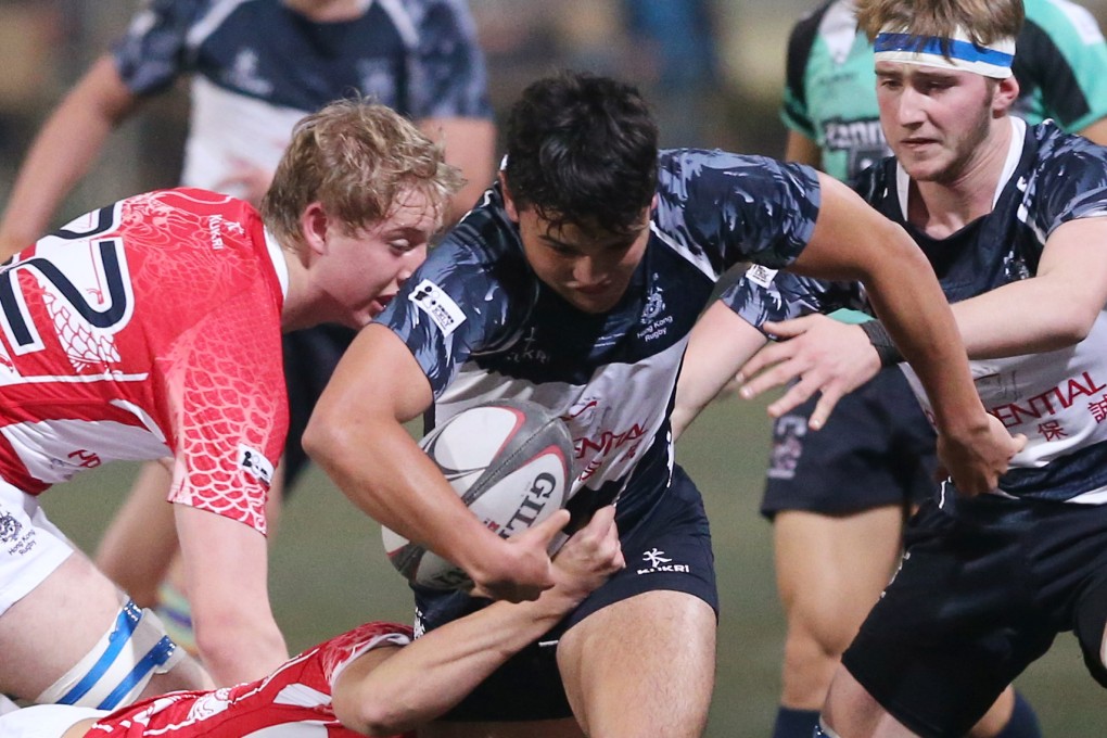 Hong Kong Dragons’ Zak Baldwin (left, in red) goes in to tackle Sam Walsh of the Overseas Lions during Friday's U19 Boys match in the New Year's Day Youth Tournament. Photo: KY Cheng/SCMP