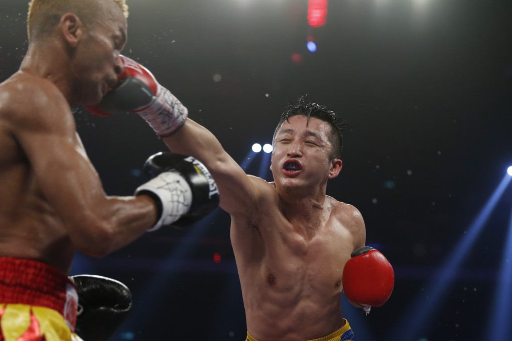 China's double Olympic gold medalist Zou Shiming, right, and Thailand's Amnat Ruenroeng exchange punches during their IBF flyweight title belt boxing match at the Venetian Macao in Macau, Saturday, March 7, 2015. Ruenroeng won the IBF flyweight title belt boxing match. (AP Photo/Kin Cheung)