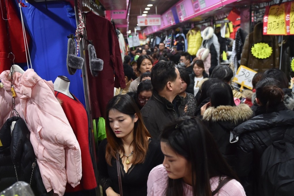 People scramble for purchasing garments at the Julong Foregin Trade Garment Store in the Zoo Market Area in the downtown Xicheng District in Beijing, China. Photo: Xinhua