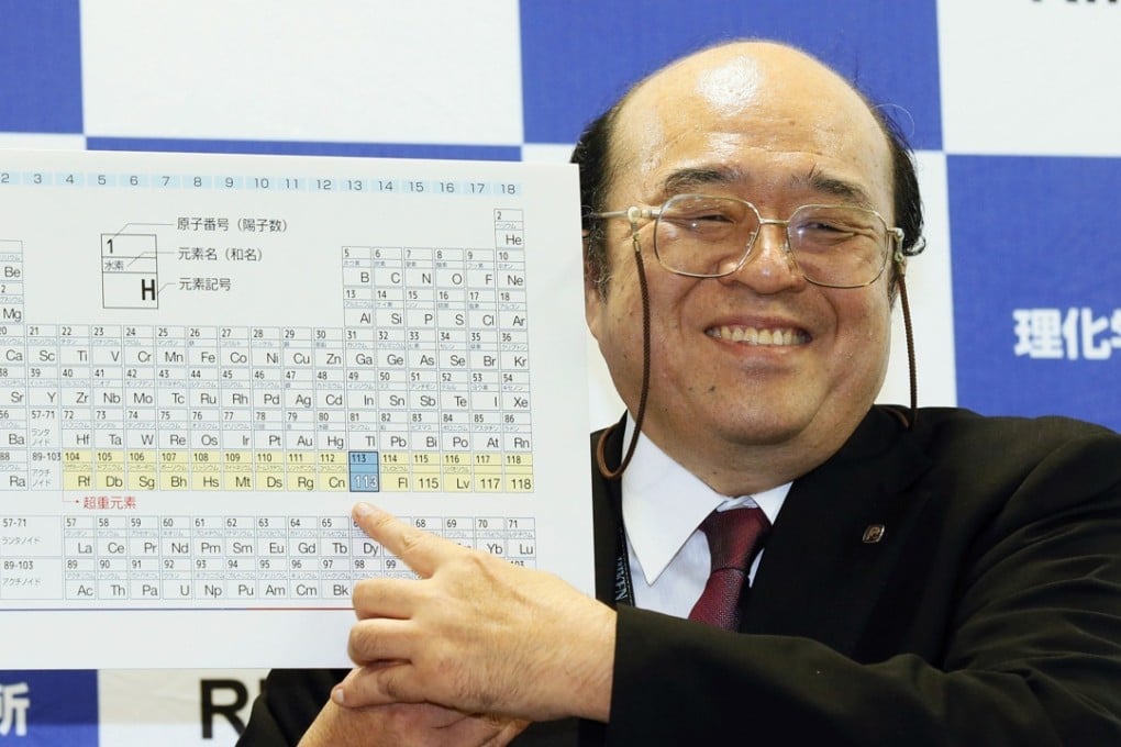 Kosuke Morita of Riken Nishina Centre for Accelerator-Based Science points at periodic table of the elements during a press conference. Photo: Kyodo