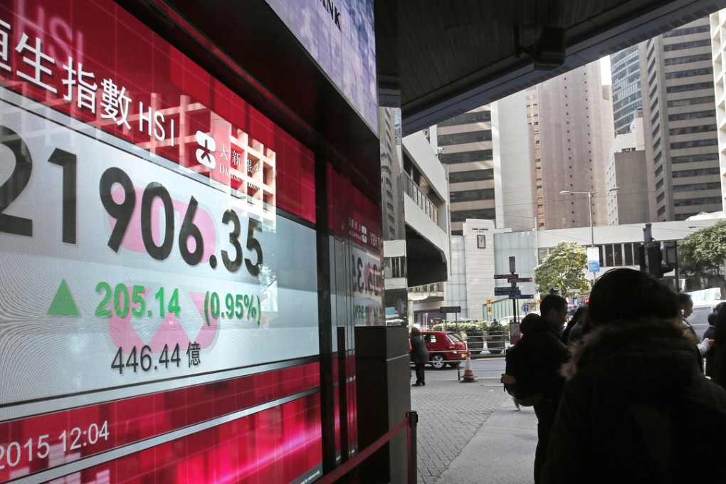 Passersby stand in front of an electronic board showing the Hong Kong share index outside a local bank in Hong Kong. The year 2015 is a banner time for share buy-backs in the exchange. Photo: AP