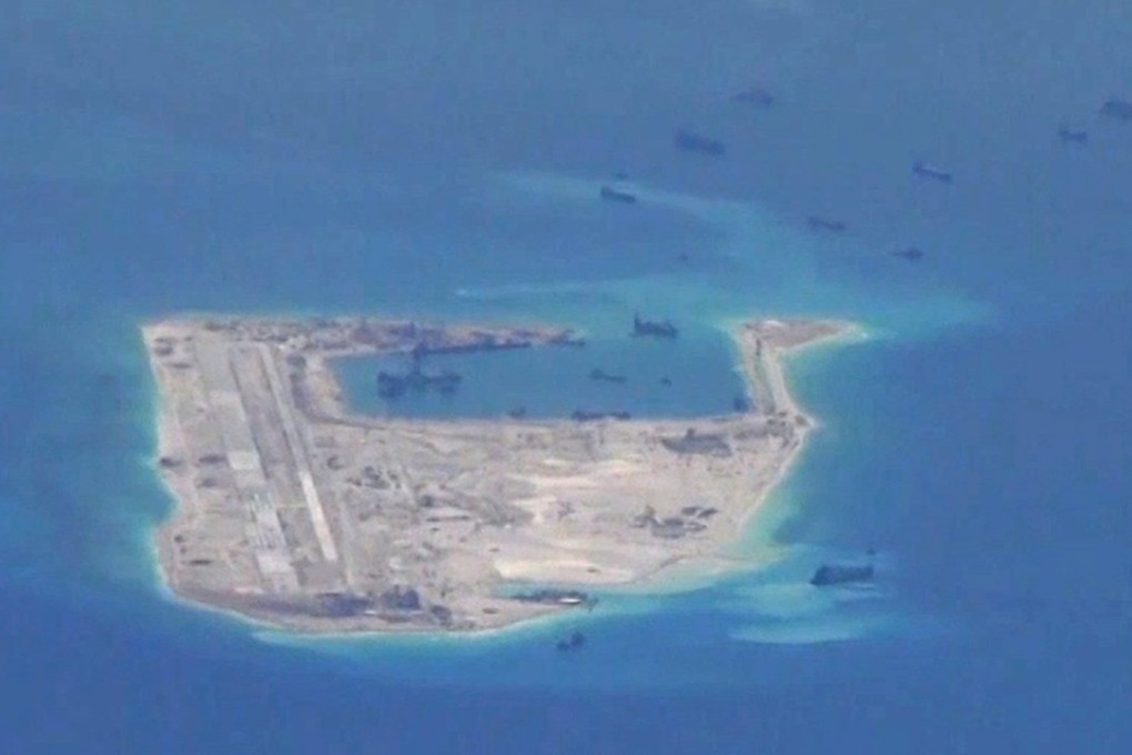 Chinese dredging vessels are purportedly seen in the waters around Fiery Cross Reef in the disputed Spratly Islands in the South China Sea in this still image from video provided by the United States Navy. On Saturday, China announced that one of its aircraft had landed on the airstrip which can be seen on the right of the image. Photo: Reuters