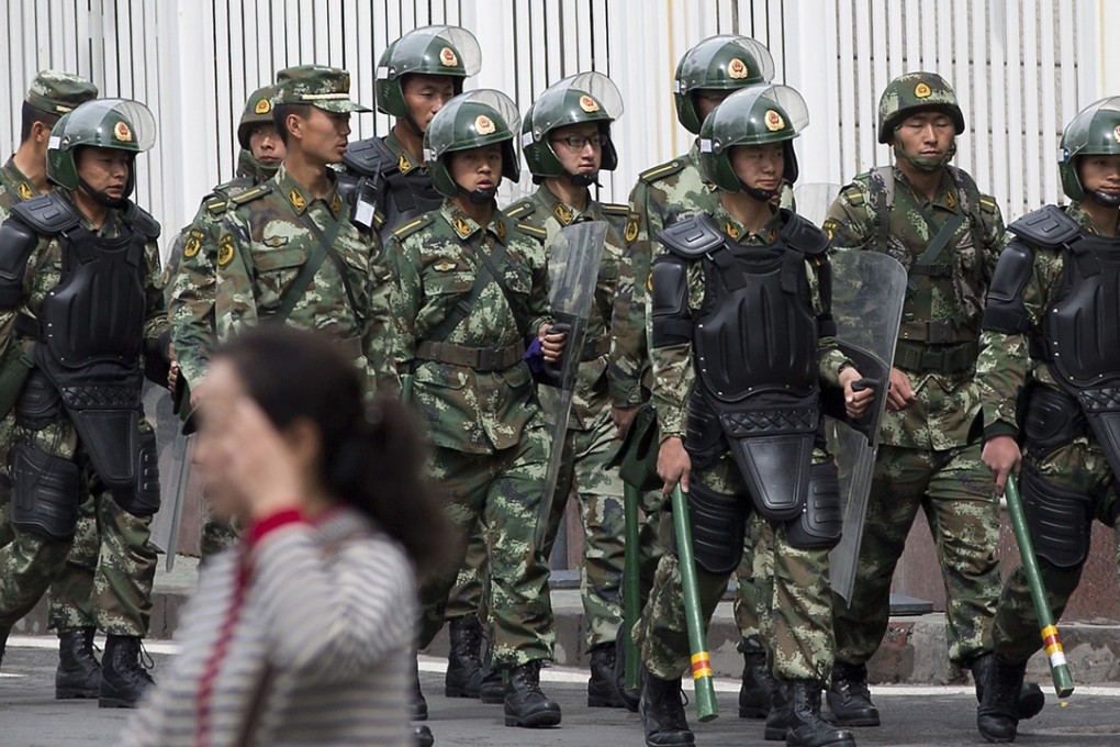 Chinese paramilitary policemen with shields and batons patrol near the People’s Square in Urumqi, China’s northwestern Xinjiang region. Photo: AP