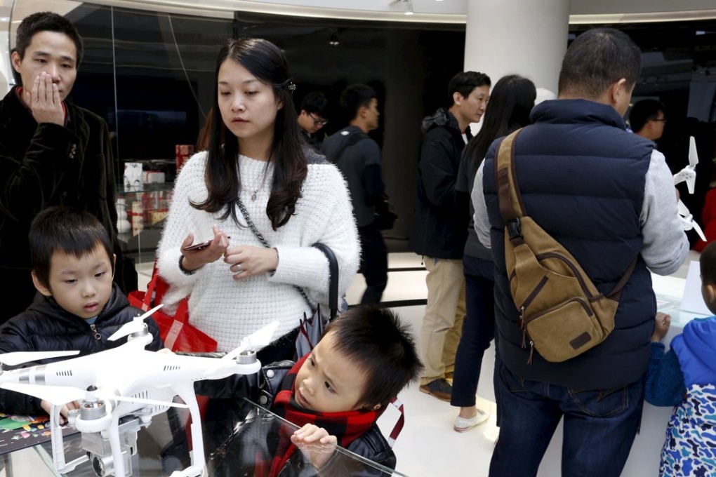 Customers look at a DJI's Phantom 3 drone at their first flagship store in Shenzhen. Photo: Xinhua