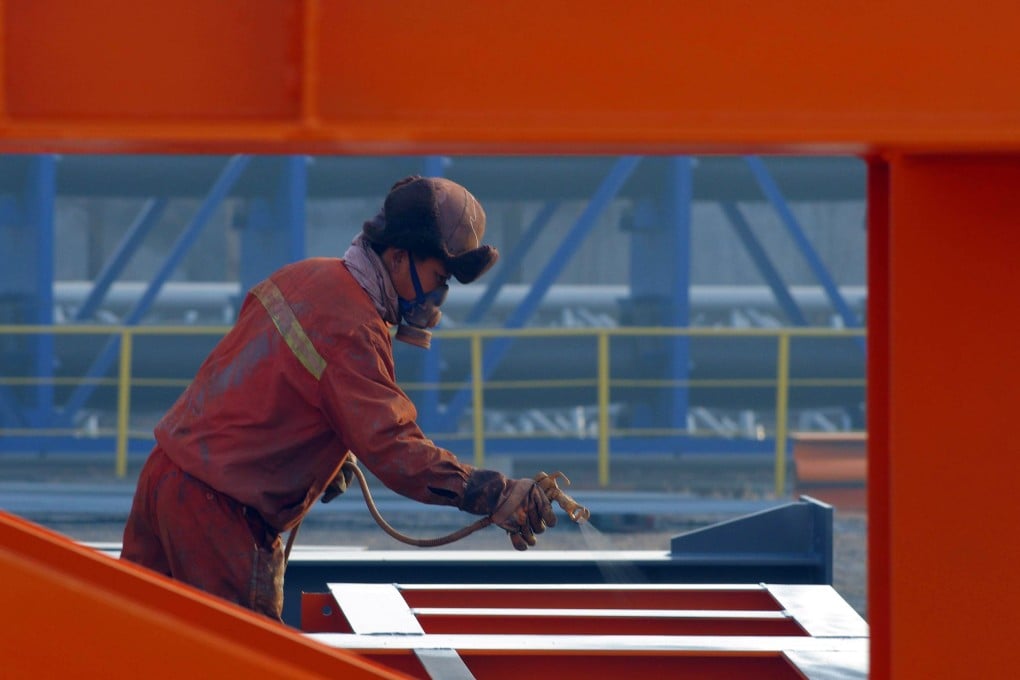 This picture taken on January 2, 2016 shows a Chinese worker spraying lacquer on steel in a factory in Rizhao, east China's Shandong province. China's factory activity shrank further in December, a private survey showed on January 4, the 10th consecutive month of contraction with the world's second-largest economy set to post its weakest growth in a quarter of a century. CHINA OUT AFP PHOTO