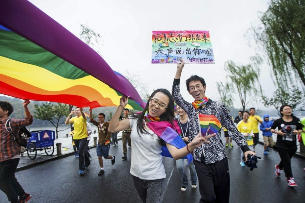 Gay rights activists run with the rainbow flag during a marathon in Hangzhou, eastern China's Zhejiang province. Photo: AP