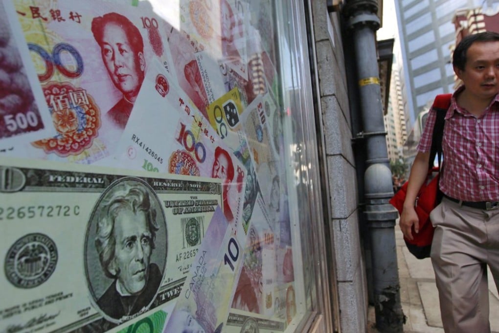 A man walks past an oversized Chinese yuan (RMB) note, US dollar and other foreign currencies in Hong Kong as the offshore yuan hits a record low on Thursday. Photo: EPA