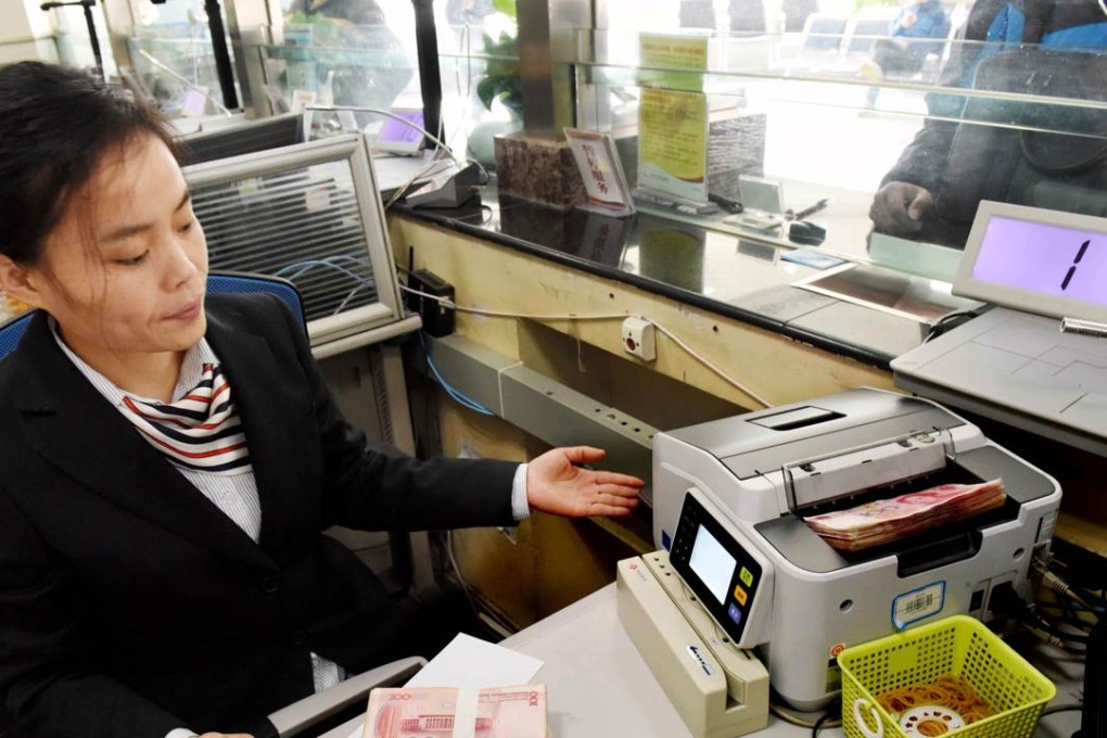 An employee counts 100-yuan banknotes at a bank in Lianyungang, Jiangsu province, on Thursday. Photo: AFP