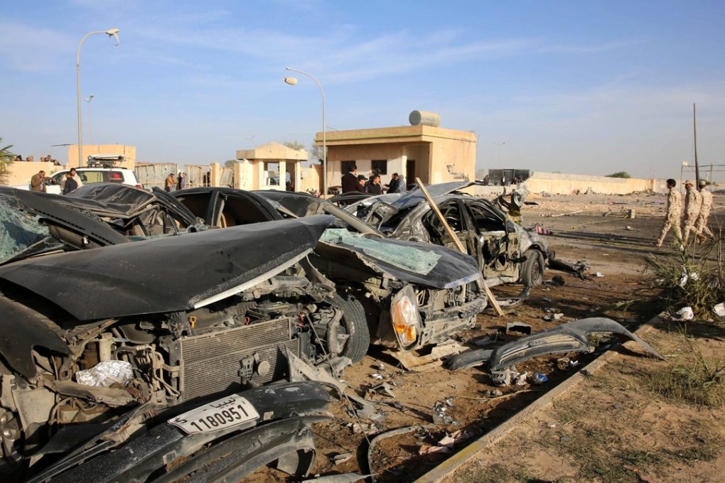 Security officers walk next damaged cars at the site where a truck bomb exploded at a police academy in the north-western coastal city of Zliten, Libya, on Thursday. Photo: EPA