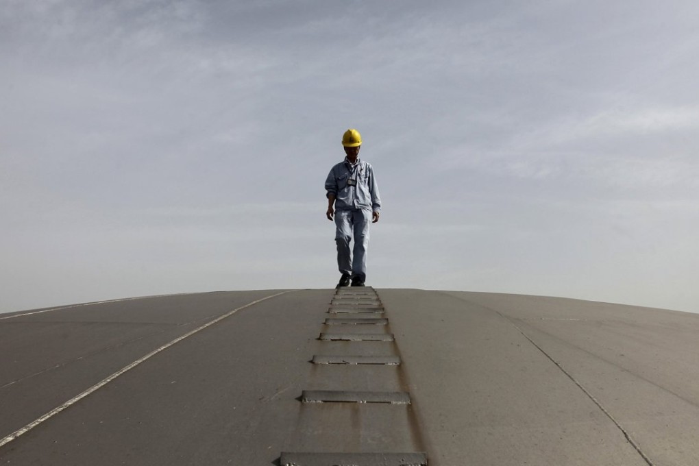 An employee walks on top of an oil tank at a Sinopec refinery in Wuhan, Hubei province. Photo: Reuters