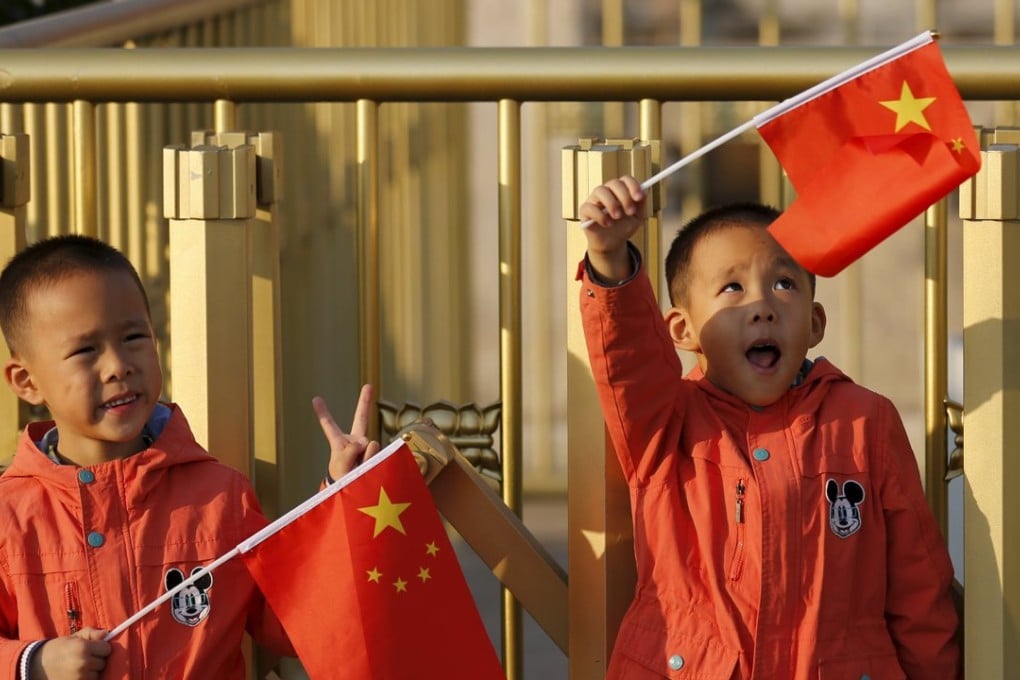 Twin boys wave national flags in Beijing. Two-child families will create a surge in spending. Photo: Reuters