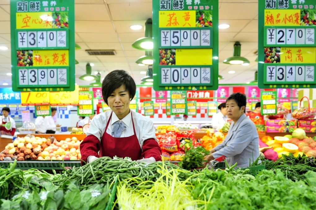 A seller arranges vegetables at a supermarket in Cangzhou, north China's Hebei Province. Fresh vegetables shot up 7. 4 per cent in December but overall food prices rose 1.5 per cent for the month in China. Photo: Xinhua