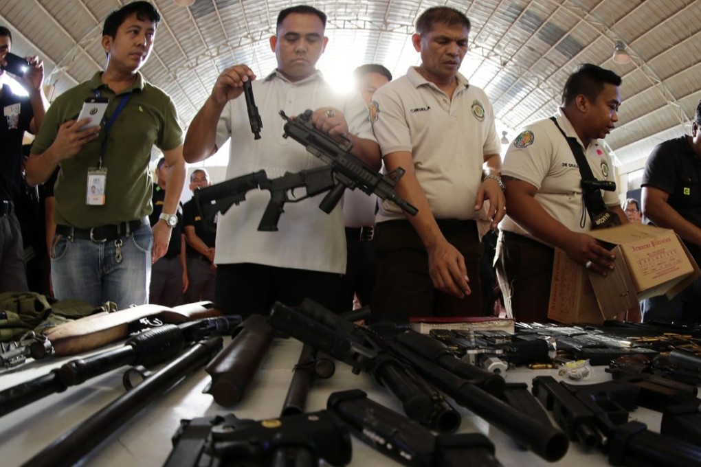 Filipino jail officers inspect confiscated firearms following a raid at the national prison in Muntinlupa city, south of Manila, Philippines in November 2015. Photo: EPA