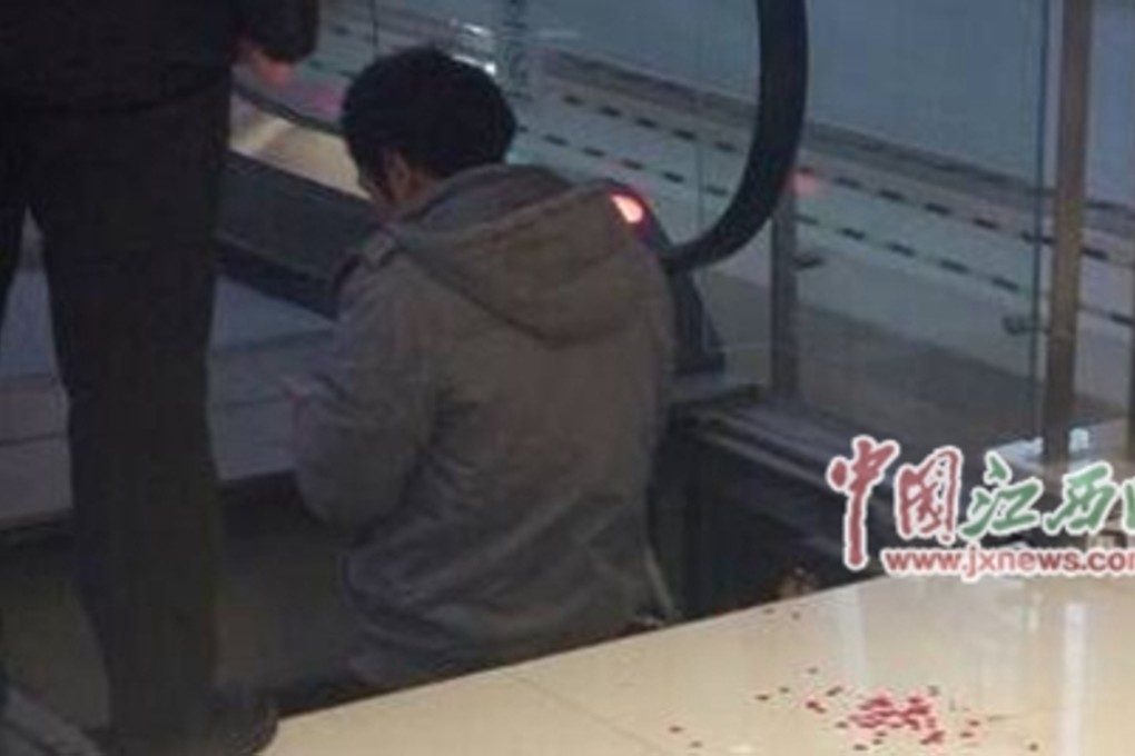 A maintenance worker recovers the girl’s severed finger at the mall in Jian in Jiangxi province. Photo: SCMP Pictures