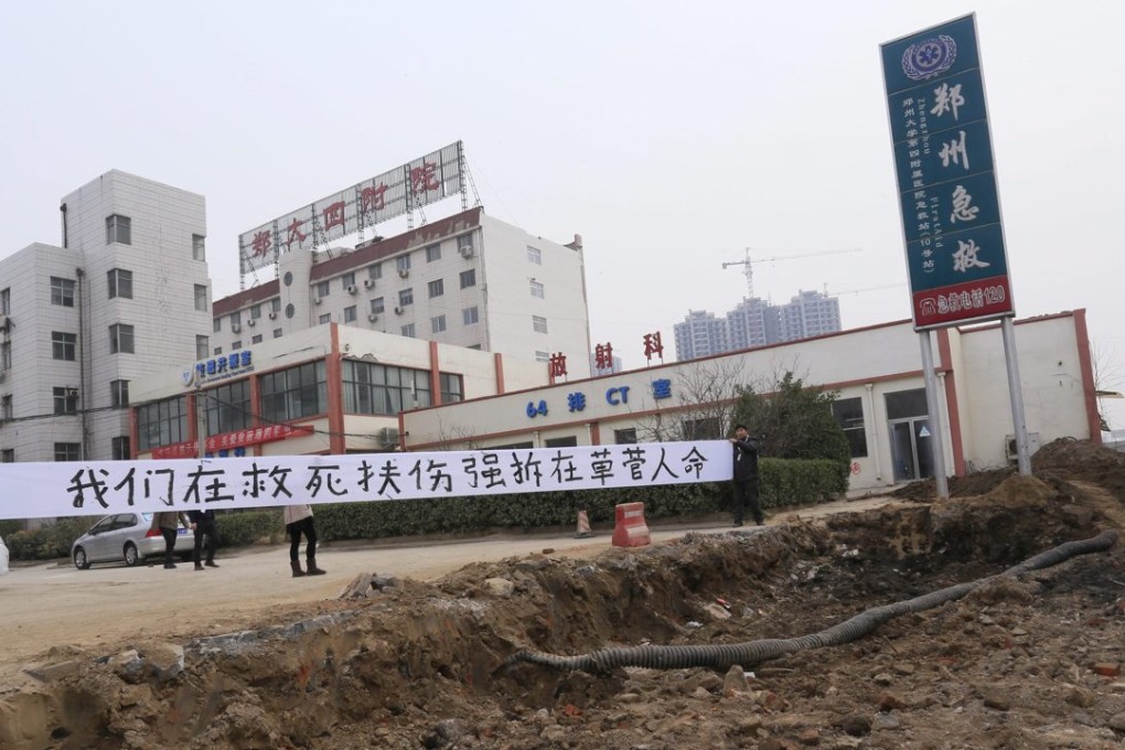 Hospital workers put up a banner saying 'We are saving lives while the forced demolition is trashing lives' after a building in a hospital was demolished in Zhengzhou in Henan province. Photo: EPA