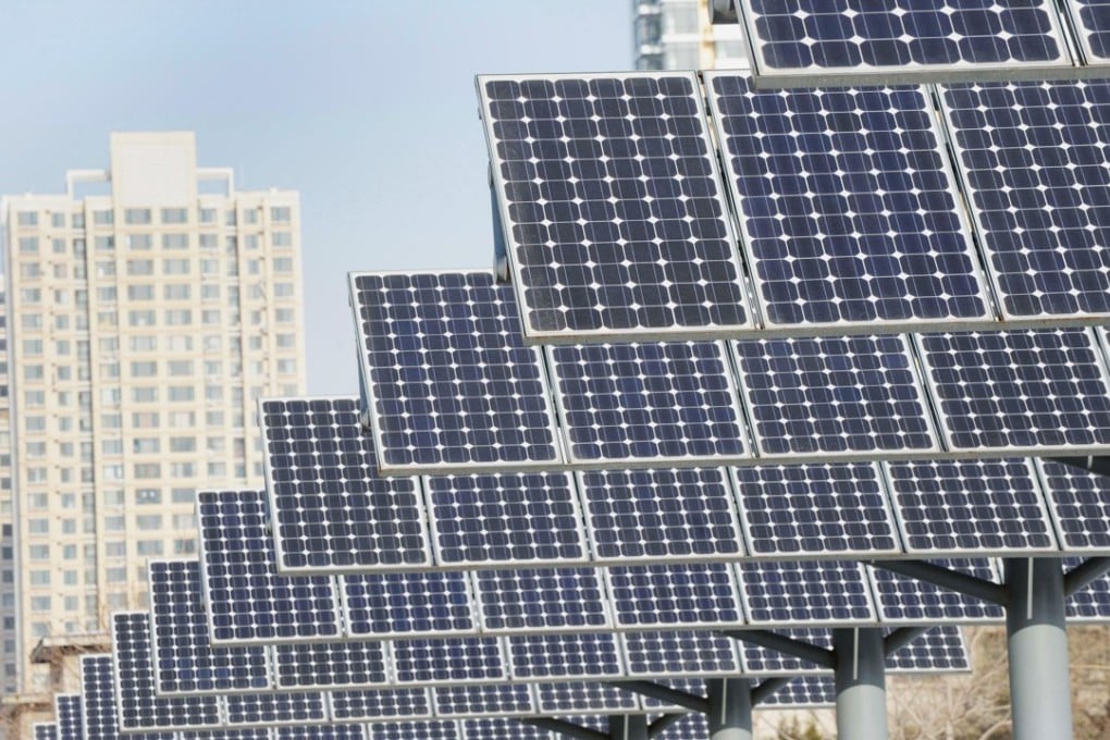 Residents walk past a line of solar power panels installed for public electricity supply in Shenyang, in northeast China's Liaoning province. Photo: AFP