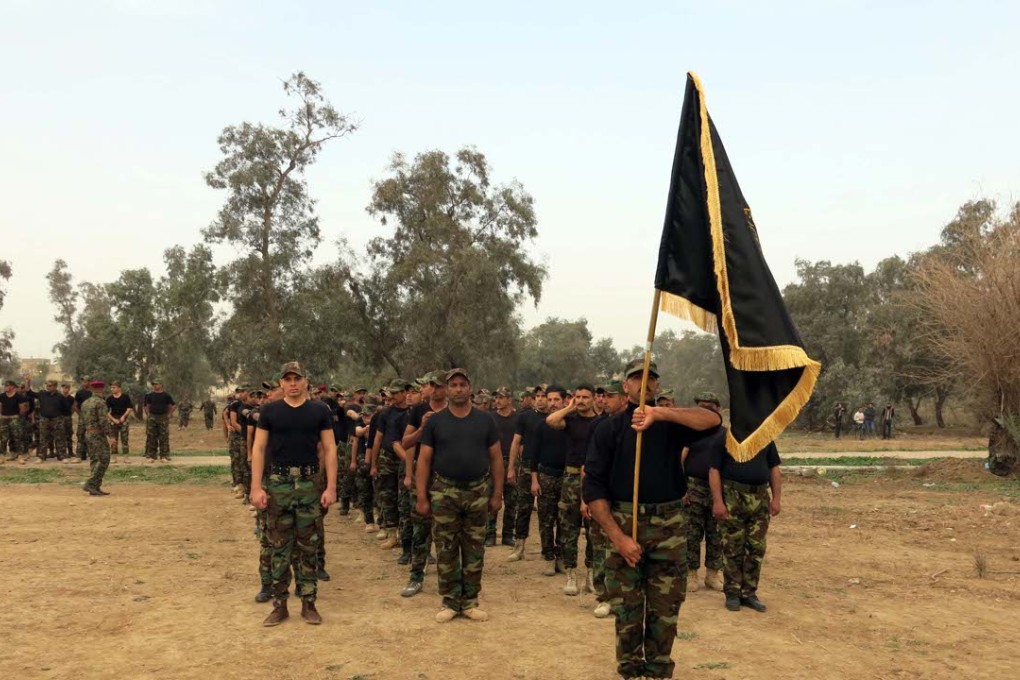 Fighters from Shiite paramilitary groups, known as Hashid Shaabi, or Popular Mobilisation are reviewed at the end of their training west of Baghdad, Iraq on January 9, 2016. Photo: Xinhua