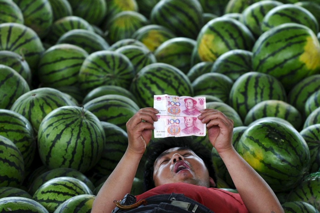 A watermelon vendor looks at yuan banknotes at a market in Changzhi, Shanxi province. Photo: Reuters