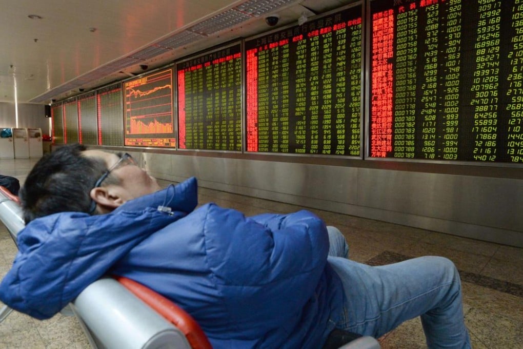 An investor takes a nap in front of an electric stock quotation board at a securities company in Beijing on January 7 after trading on the Shanghai and Shenzhen stock markets was halted for the day. Photo: Kyodo