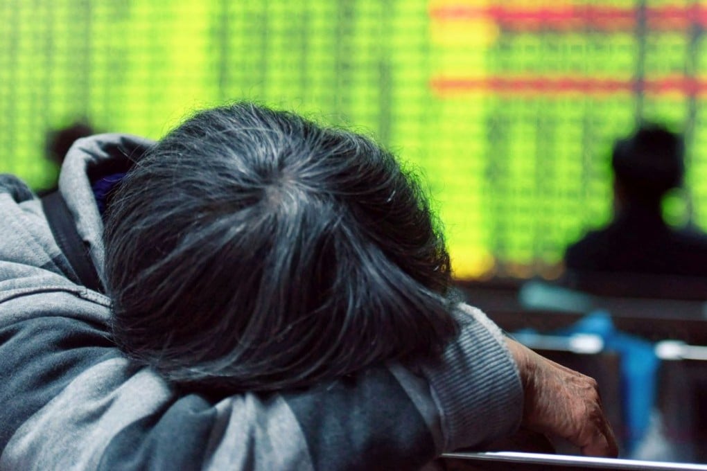 An investor rests in front of a screens showing stock market movements at a securities firm in Hangzhou, Zhejiang province, on Monday. Photo: AFP