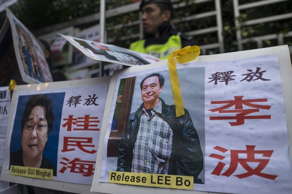 Photos of the missing bookstore shareholders Gui Minhai, (L), and Lee Bo — who are believed to have been detained in mainland China — are taped to barriers outside the China Liaison Office during a protest in Hong Kong, 10 January 2016. Photo: EPA