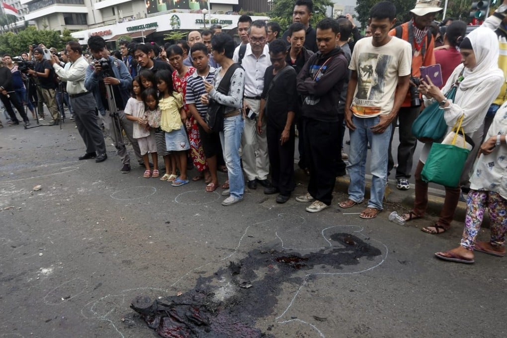 Residents inspect the site after a bomb blast in front of a shopping mall. Photo: EPA/ADI WEDA