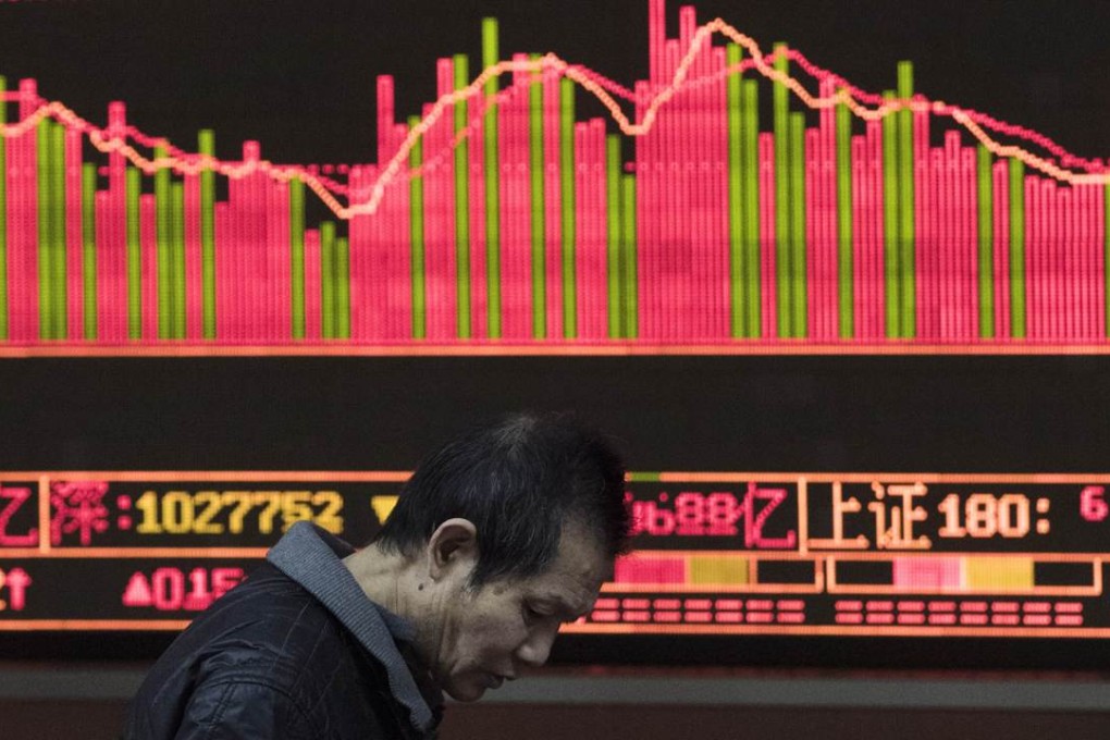 An investor walks in front of a screen showing stock market movements at a securities company in Beijing. Photo: AFP