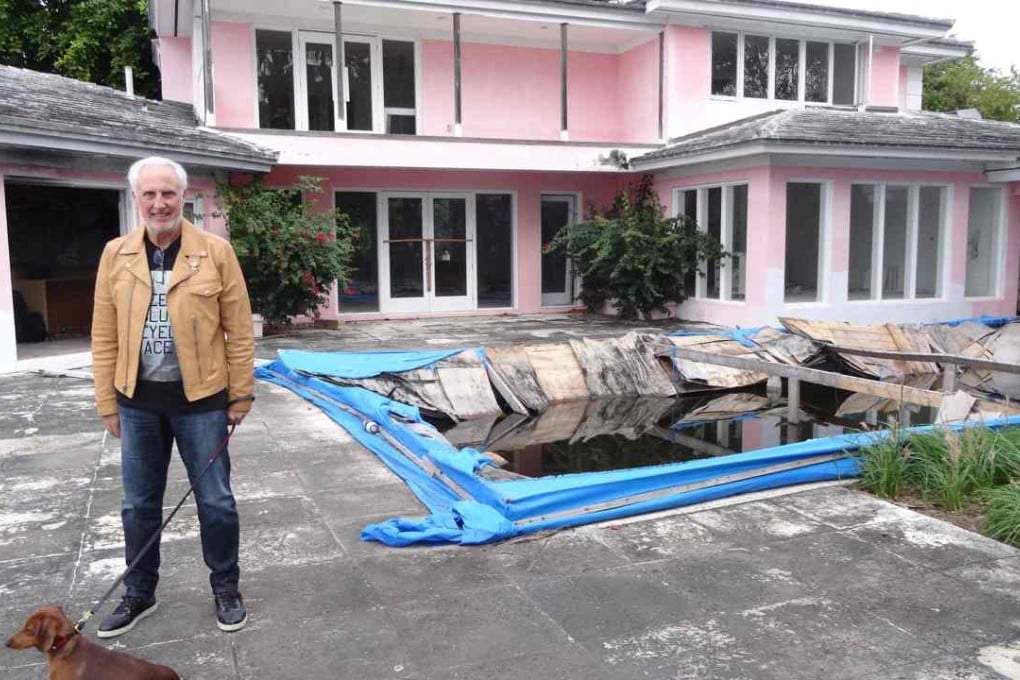 Christian de Berdouare stands with his dog in front of a house that used to belong to late Colombian drug lord Pablo Escobar. De Berdouare, the property’s current owner, will next week demolish the mansion. Photo: AFP