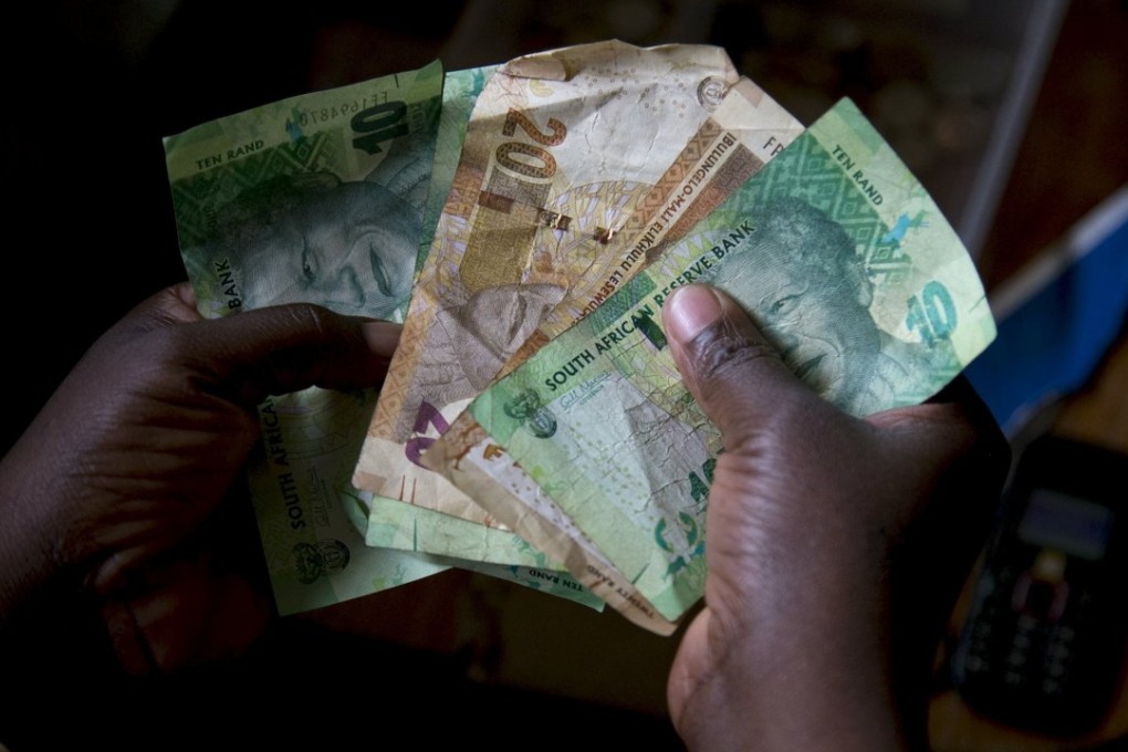 A shopkeeper counts out change above her cash box at her shop in Hillcrest, west of Durban, South Africa, on Monday. Photo: Reuters