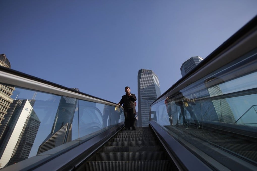 A file photo of a man descending on an escalator at the Lujiazui financial district of Pudong in Shanghai. Photo: Reuters